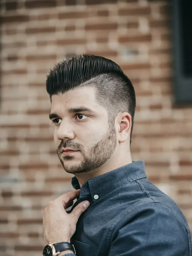 Corte social com topete penteado para trás e laterais baixas